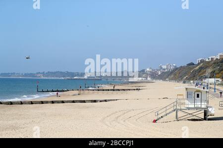 Die Menschen gehen an einem einsamen Strand von Boscombe entlang, während Großbritannien weiterhin in Sperrungen bleibt, um die Ausbreitung des Coronavirus einzudämmen. Stockfoto