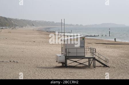 Die Menschen gehen an einem einsamen Strand von Boscombe entlang, während Großbritannien weiterhin in Sperrungen bleibt, um die Ausbreitung des Coronavirus einzudämmen. Stockfoto