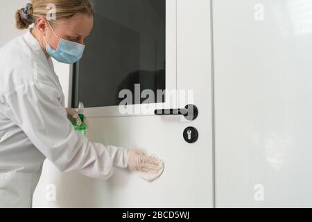 Bei Verwendung von Wet Wipe und Alkoholdesinfektionsspray wird der Türgriff desinfiziert. Desinfektion, Sauberkeit und Gesundheitsversorgung, Anti Coronavirus COVID-19 Stockfoto