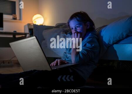 Junge, zu Hause auf dem Computer, Laptop, im Kinderzimmer, spielen ein Spiel, Stockfoto