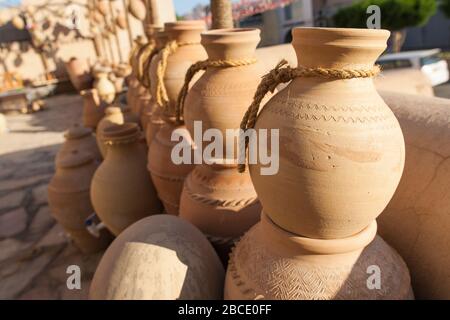 Traditionelle omanische Aufbewahrungsbecher und Urnen zum Verkauf in einem Souvenir- und Handwarenladen in Nizwa Souk, Nizwa, Oman. Stockfoto