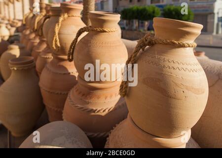 Traditionelle omanische Aufbewahrungsbecher und Urnen zum Verkauf in einem Souvenir- und Handwarenladen in Nizwa Souk, Nizwa, Oman. Stockfoto