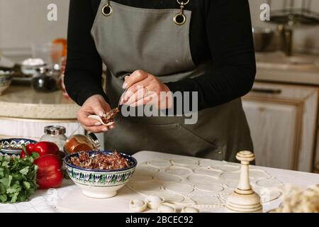 Herstellung von Knödel, Manti und Khinkali aus Hackfleisch, Lamm und Teig. Hausgemachte Speisen. Stockfoto
