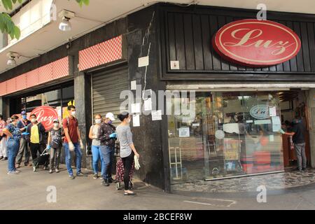 Caracas, Venezuela 31. März 2020: Menschen, die Schutzmasken tragen, die auf Linien stehen und auf Kurven warten, um während der Quarantänekrise einen Supermarkt zu betreten Stockfoto