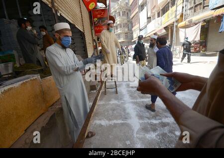 Peschawar, Pakistan. April 2020. Menschen stehen in der Ferne, um während einer landesweiten Sperre Lebensmittel zu kaufen, um den Ausbruch des Corona-Virus zu verhindern (Foto von Hussain Ali/Pacific Press) Kredit: Pacific Press Agency/Alamy Live News Stockfoto