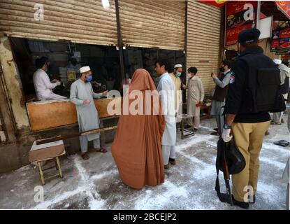 Peschawar, Pakistan. April 2020. Menschen stehen in der Ferne, um während einer landesweiten Sperre Lebensmittel zu kaufen, um den Ausbruch des Corona-Virus zu verhindern (Foto von Hussain Ali/Pacific Press) Kredit: Pacific Press Agency/Alamy Live News Stockfoto