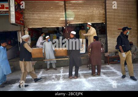 Peschawar, Pakistan. April 2020. Menschen stehen in der Ferne, um während einer landesweiten Sperre Lebensmittel zu kaufen, um den Ausbruch des Corona-Virus zu verhindern (Foto von Hussain Ali/Pacific Press) Kredit: Pacific Press Agency/Alamy Live News Stockfoto