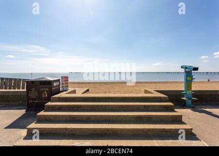 Southend-on-Sea, Großbritannien. April 2020. Blick auf Southends City Beach an einem warmen Frühlingstag während der COVID-19-Pandemie. Betonstufen führen hinunter zum Sand, flankiert von öffentlichen Müll- und Recyclingbehältern und einem blauen Teleskop. Die Szene spiegelt soziale Distanzierungsmaßnahmen und Umweltbewusstsein wider, wobei der Southend Pier in der Ferne unter klarem Himmel sichtbar ist. Penelope Barritt/Alamy Live News Stockfoto