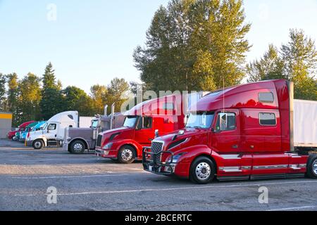 Rastplatz. Verschiedene Lkw-Typen auf dem Parkplatz neben der Autobahn. Stockfoto