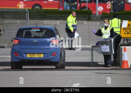 AUTOKENNZEICHEN PIXEATED VON PA PICTURE DESK EIN Mitarbeiter mit PSA hält einen Behälter mit der Aufschrift "Test Kits Only" an einem Coronavirus Testgelände in einem Parkplatz in der Nähe des O2 in Greenwich, London, da das Vereinigte Königreich weiterhin in Lockdown arbeitet, um die Ausbreitung des Coronavirus einzudämmen. Stockfoto