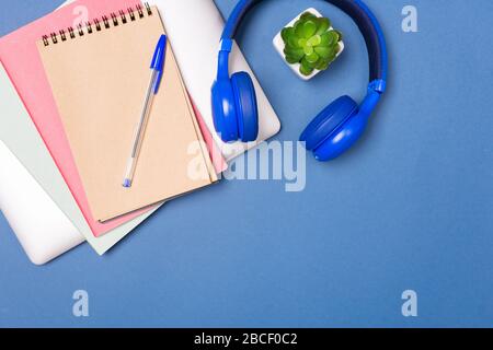 Blick auf den farbenfrohen Schreibtisch. Laptop, Notebook, Ohrhörer. Heimarbeitbüro. Kreativität. Kreative Arbeit. Freiberuflich Tätig. Schulschreibtisch. Kopieren Stockfoto