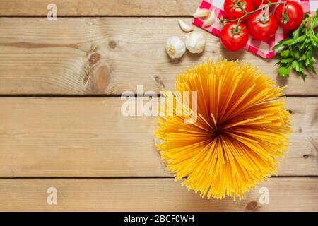 Spaghetti-Pasta mit Tomaten Knoblauch und Petersilie auf Holzgrund. italienische Flaggenfarben. Stockfoto