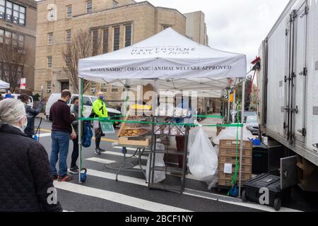 Menschen, die während der Coronavirus-Pandemie auf einem Bauernmarkt in New york Lebensmittel kaufen, tragen Masken. Seil um den Lebensmittelstand halten sie sechs Meter entfernt Stockfoto