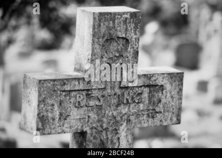 Ein Schwarz-Weiß-Foto eines christlichen Kreuzgrabsteins auf einem Friedhof, Großbritannien Stockfoto