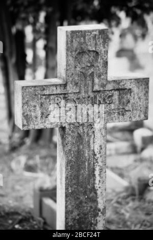 Ein Schwarz-Weiß-Foto eines christlichen Kreuzgrabsteins auf einem Friedhof, Großbritannien Stockfoto