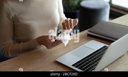 Junge Frau, die ein antiseptisches Gel auf Papiergewebe auftragen. Stockfoto