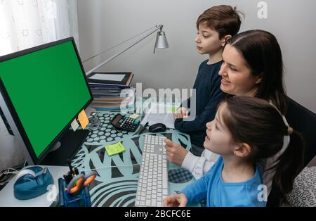 Mutter und Kinder, die auf den Computerbildschirm schauen Stockfoto
