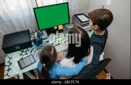 Mutter und Kinder, die auf den Computerbildschirm schauen Stockfoto