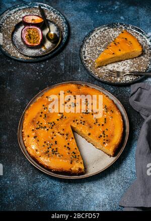 Hausgemachte Mango-Kuchen mit Passionsfrucht und einem Stück auf einem Teller abgeschnitten. Tropisches Dessert im Sommer. Selektiver Fokus. Stockfoto