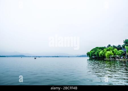 großer See mit weißem Himmel Hintergrund und Bäumen Stockfoto