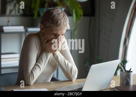 Verunglückte 30er-Dame, die den Mund mit den Händen bedeckt, die niesen oder husten. Stockfoto