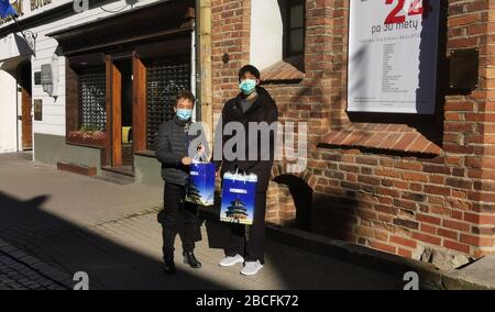 (200404) -- WILNA, 4. April 2020 (Xinhua) -- Berater Qu Baihua (L) der chinesischen Botschaft in Litauen verteilt Masken an einen chinesischen Studenten in Vilnius, Litauen, 30. März 2020. Die chinesische Botschaft in Litauen verteilte Gesundheitssätze, die aus Gesichtsmasken bestehen, an die ausländischen chinesischen Studenten in Vilnius und Kaunas. (Chinesische Botschaft nach Litauen/Übergabe über Xinhua) Stockfoto