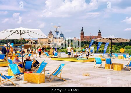 Gestin, Polen, Juni 2018 auf Sonnenliegen am Kai und an der Promenade der Altstadt entspannen. Nationalmuseum und Passportbüro im Hintergrund Stockfoto