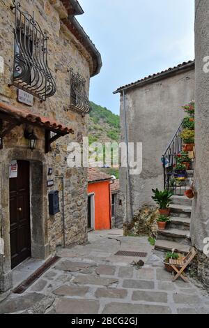 Eine schmale Straße zwischen den Häusern eines kleinen Bergdorfs in der Region Basilikata in Italien Stockfoto