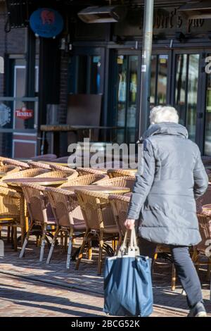 Leere Stühle und Tische vor einer Restaurantbar in der niederländischen Stadt Veenendaal, die wegen des Ausbruchs des Coronavirus geschlossen werden musste Stockfoto