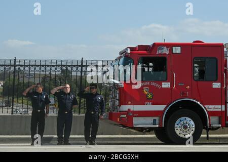 Riverside, Kalifornien, USA. April 2020. Feuerwehrleute stehen auf ihrem Feuerwehrauto, um der vorbeifahrenden Prozession des Körpers von David Werksman auf der Interstate 15, Freitag, 3. April 2020, in Corona, Kalifornien, zu Ehren zu kommen. Riverside County Sheriff Chad Bianco gab zuvor die Verabschiedung des stellvertretenden David Werksman bekannt, der an Komplikationen des Romans COVID-19 starb. Werksman ist der zweite Mitarbeiter des County Sheriffs, der aufgrund des Coronavirus starb. (Foto von IOS/Espa-Images) Credit: European Sports Photographic Agency/Alamy Live News Stockfoto