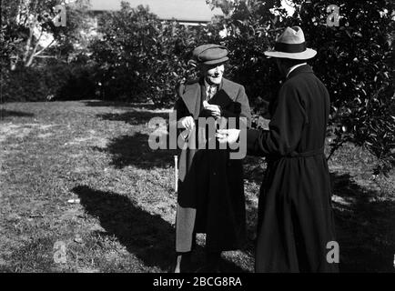 Der amerikanische Wirtschaftsmagnat und Philanthrope John D. Rockefeller (1839 - 1937) im Gespräch mit einem anderen Mann außerhalb, Florida, 1920er Jahre. (Foto von Burton Holmes) Stockfoto