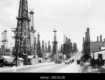 Öldderricks in der Nähe einer Straße in Long Beach, Kalifornien, 1920er Jahre. Fotografie von Burton Holmes. Stockfoto