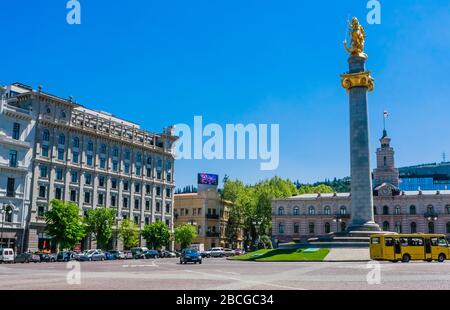 Freedom and Victory Square mit dem Freedom Monument, das die St. George Statue in einer zentralen Säule zeigt. Tiflis Rathaus dahinter. In Shota Rustavel Stockfoto