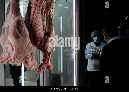 Palästinenser, die wegen der COVID-19-Pandemie des Coronavirus Gesichtsmaske tragen, stehen neben einer Metzgerei in Beit Habad, auch an der Khan az Zait Straße in der Altstadt des Muslimischen Viertels, Ostjerusalem Israel Stockfoto