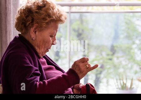 Ältere Frau am Fenster Stockfoto