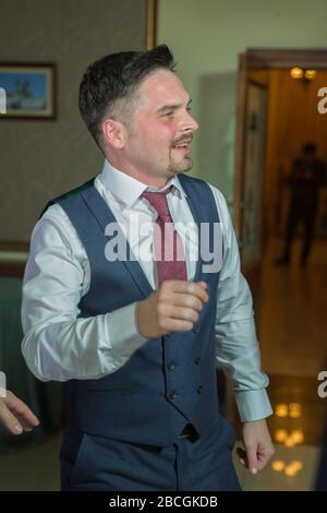 Fröhlicher, schöner Bräutigam, der an der Rezeption Spaß macht. Bräutigam mit Spaß beim Tanzen an der Hochzeitsfeier. Die Männer tanzen auf der Hochzeit. Baku Stockfoto
