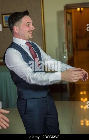 Fröhlicher, schöner Bräutigam, der an der Rezeption Spaß macht. Bräutigam mit Spaß beim Tanzen an der Hochzeitsfeier. Die Männer tanzen auf der Hochzeit. Baku Stockfoto