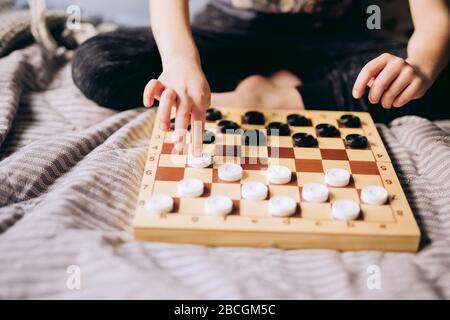 Junge Kinder spielen mit den Schachspielen ein Tischspiel im Bett. Bleiben Sie zu Hause Quarantänekonzept. Freizeitkonzept für Brettspiele und Kinder. Familienzeit. Stockfoto