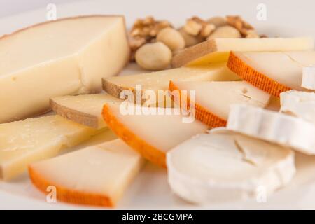 Abwechslungsreiche Käseplatte mit Ziegenkäse, Rulo, Kuchen, Manchego und Nüssen. Stockfoto