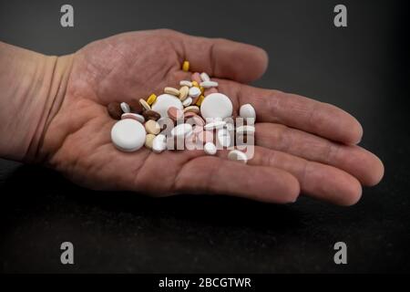 Ein Mann hält verschiedene Tabletts in der Hand. Stockfoto