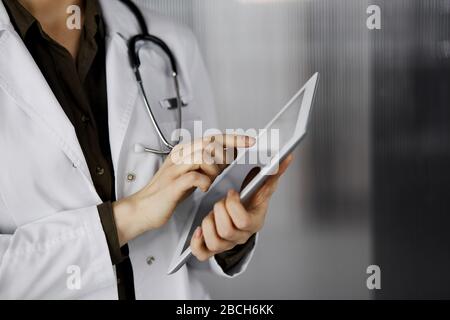 Unbekannter weiblicher Arzt mit Tablet-Computer in der Klinik. Perfekter medizinischer Service im Krankenhaus. Medizinkonzept Stockfoto