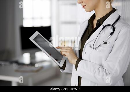 Unbekannter weiblicher Arzt mit Tablet-Computer in der Klinik. Perfekter medizinischer Service im Krankenhaus. Medizinkonzept Stockfoto