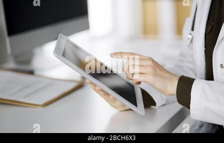 Unbekannter weiblicher Arzt mit Tablet-Computer in der Klinik. Perfekter medizinischer Service im Krankenhaus. Medizinkonzept Stockfoto