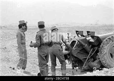 Afghanische Soldaten laden auf dem Pagaman Forward Operating Post vom 1. Mai 1989 in Pagaman, Afghanistan, in eine aus der Sowjetunion gefertigte 122-mm-Kanone. Die Basis schützt einen Haupteinstiegspunkt in die Hauptstadt Kabul und ist weniger als eine Meile von den Frontlinien der afghanischen Mudschaheddin Fighters entfernt. Stockfoto