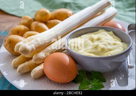 Zutaten für vegetarisches Frühlingsabendessen, hochwertiger holländisch weißer Spargel, gewaschen und an Bord geschält, bereit zum Kochen Stockfoto