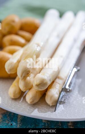 Zutaten für vegetarisches Frühlingsabendessen, hochwertiger holländisch weißer Spargel, gewaschen und an Bord geschält, bereit zum Kochen Stockfoto