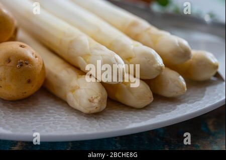 Zutaten für vegetarisches Frühlingsabendessen, hochwertiger holländisch weißer Spargel, gewaschen und an Bord geschält, bereit zum Kochen Stockfoto