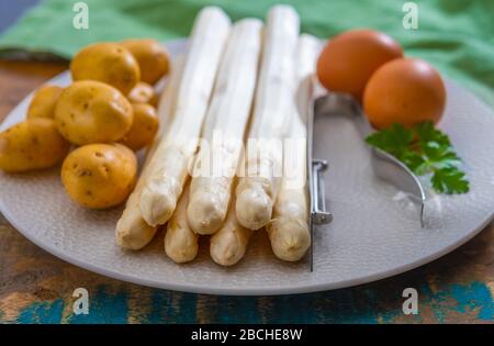 Zutaten für vegetarisches Frühlingsabendessen, hochwertiger holländisch weißer Spargel, gewaschen und an Bord geschält, bereit zum Kochen Stockfoto