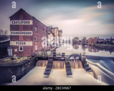 Castleford West Yorkshire, England. Morgen am Fluss Aire, Steinmühle Allinsons und Weir in der Nähe der Millennium Brücke und dem Stadtzentrum Stockfoto