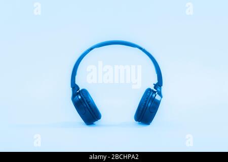 Kopfhörer auf blauem Hintergrund Nahaufnahme in Neonlicht Stockfoto